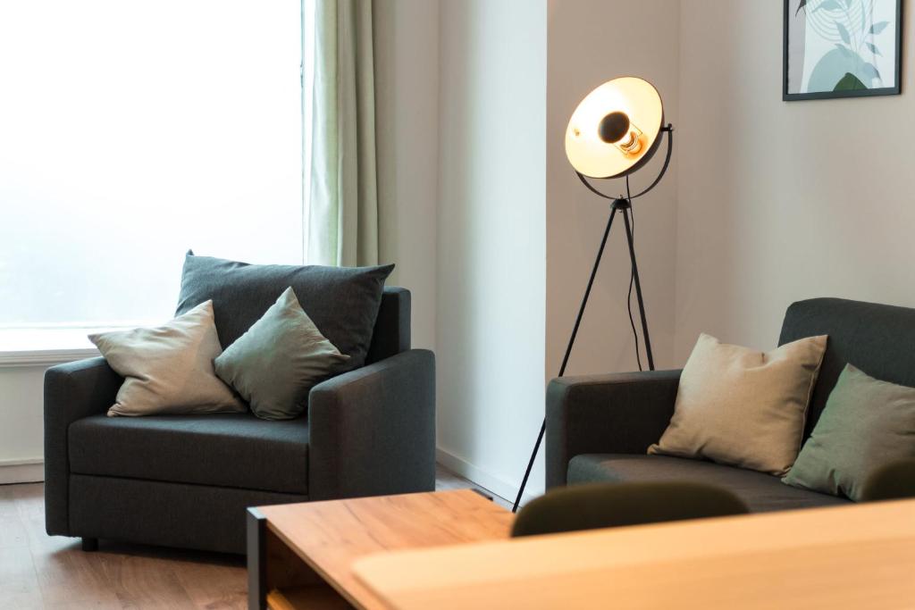 una sala de estar con 2 sofás y una lámpara de pie en Spacious 1-Bedroom Apartment in Kreuzberg, en Berlín