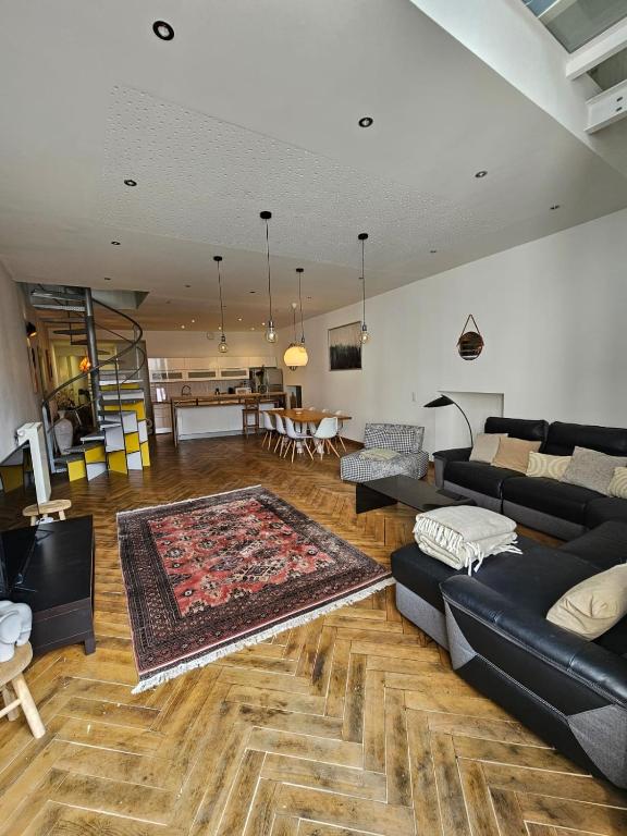 - un salon avec un canapé noir et un tapis dans l'établissement Le loft K- centre Colmar - jusqu'à 10 personnes, à Colmar