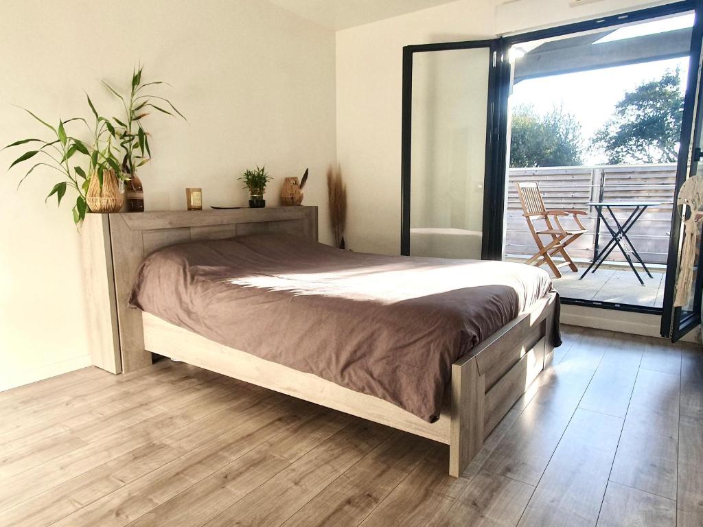 a bedroom with a bed and a balcony at Maison de famille à 300m de la plage in Labenne