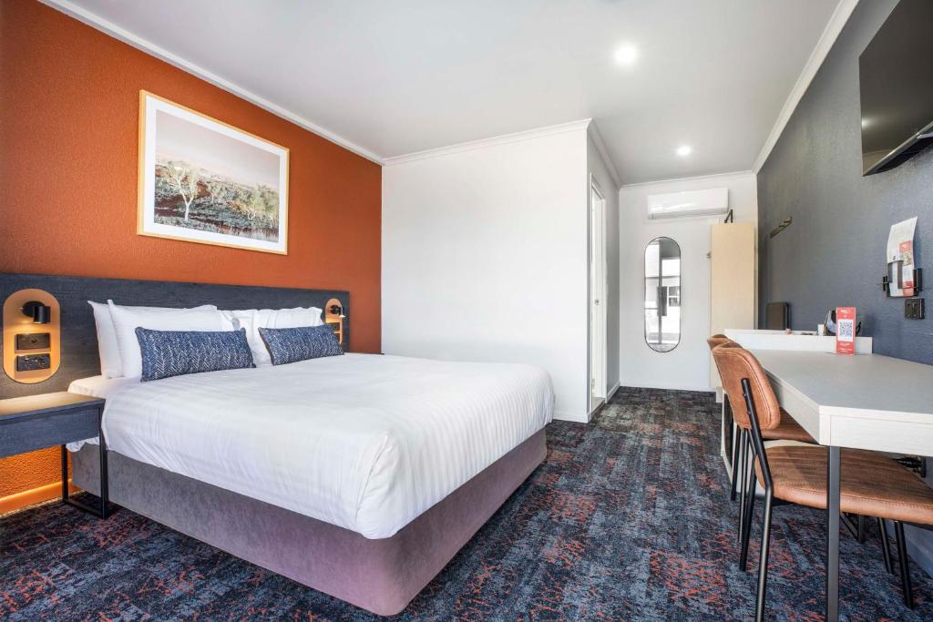 a bedroom with a bed and a table and a desk at Nightcap at Horse & Jockey Hotel Warwick in Warwick