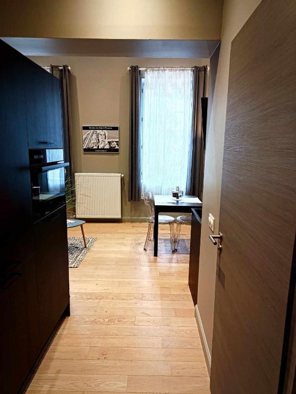 un couloir avec une table et une porte donnant sur une pièce dans l'établissement le bardo, à Aix-les-Bains