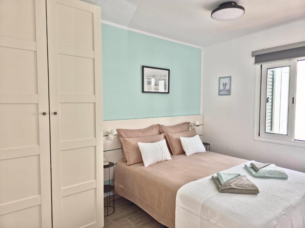 a white bedroom with a bed and a window at Bungalow Aqua Sol - Playa Roca residence - Sea front access - Free AC - WiFi in Costa Teguise