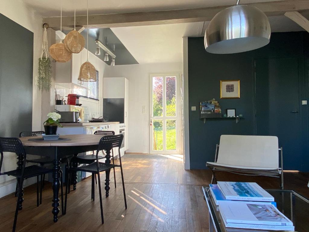 une cuisine et une salle à manger avec une table et des chaises dans l'établissement Le 7, à Mesland