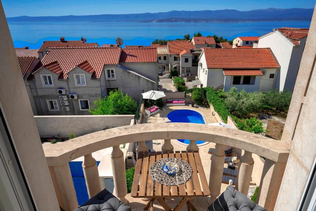 a balcony with a table and a view of a city at Hektorovic poolside apartments in Bol