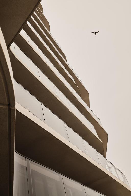 a building with a bird flying in the sky at Enso District Residences in Knokke-Heist
