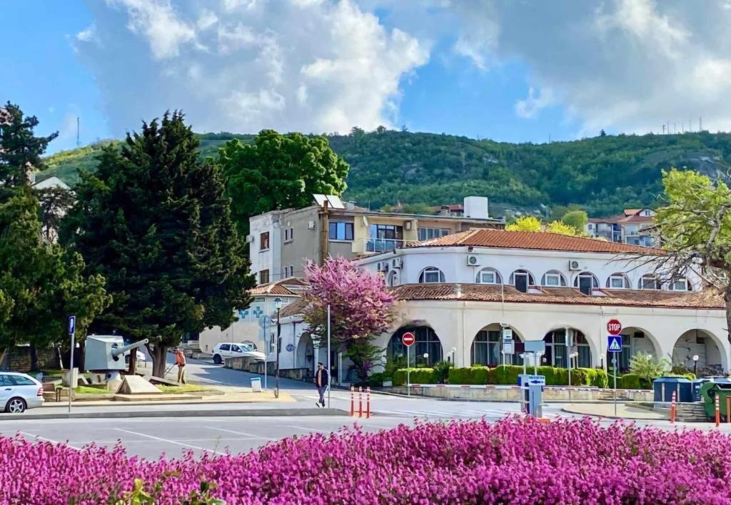 a city street with a building and purple flowers at Gardenia Guest House in Balchik