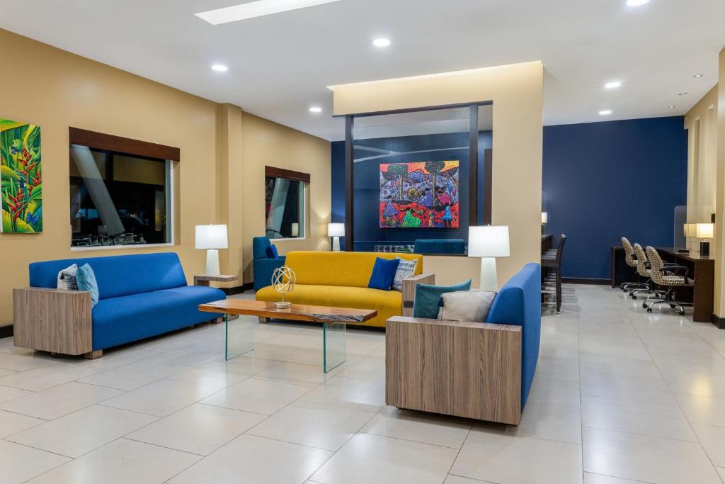 a lobby with blue and yellow couches and a table at Courtyard by Marriott San Jose Airport Alajuela in Alajuela City