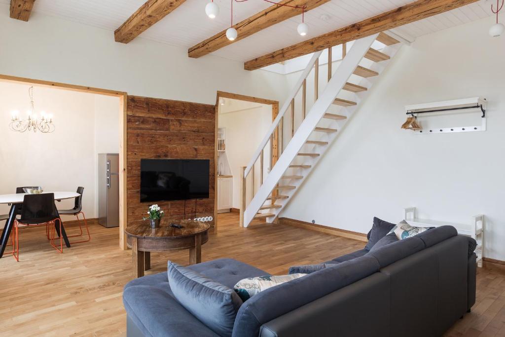 a living room with a blue couch and a staircase at Rebeca külaliskorter in Haapsalu