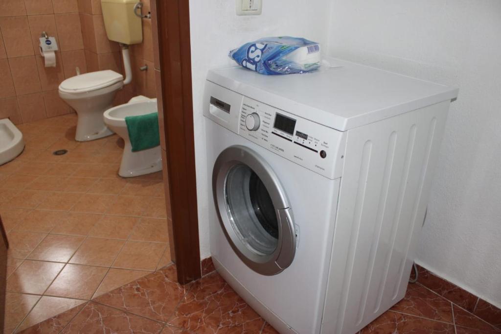 a washing machine in a bathroom with a toilet at Crew Hostel Tirana in Tirana