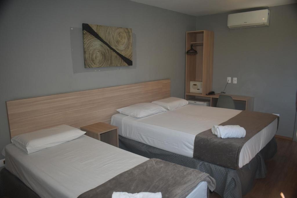 una camera d'albergo con due letti e una foto a parete di Unity Hotel - Vila Mariana SP a San Paolo
