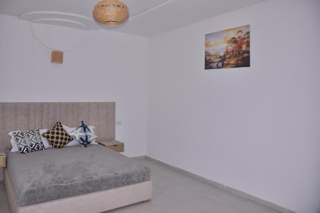 Un dormitorio con una cama y un cuadro en la pared. en Amira Suite Double with Bathroom, en Fez