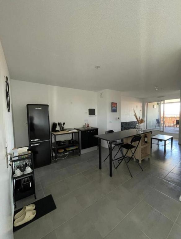 un salon avec une table et un réfrigérateur dans l'établissement Bel appart' de 47m2 au coeur de Bordeaux, à Bordeaux