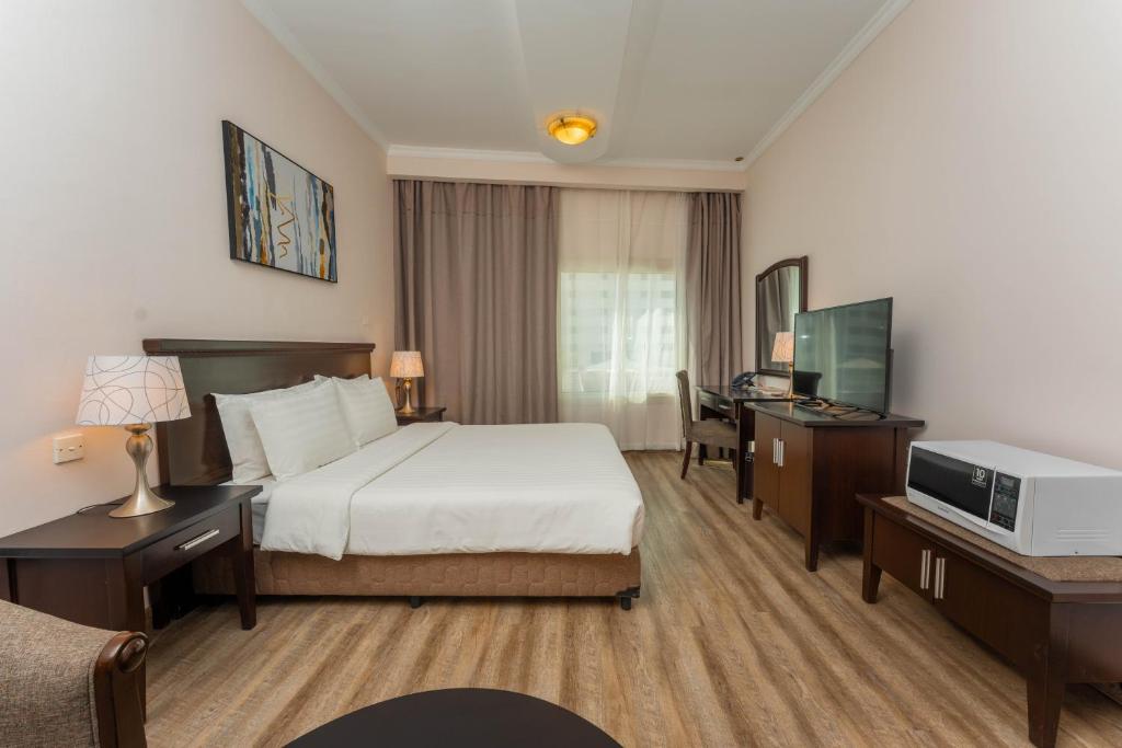una camera d'albergo con un letto e una televisione di Ezdan Hotel, Residences a Doha
