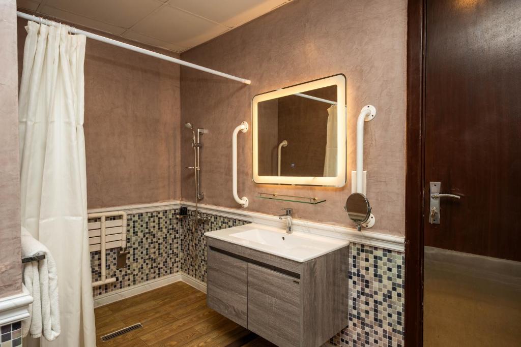 un bagno con lavandino e specchio di Ezdan Hotel, Residences a Doha
