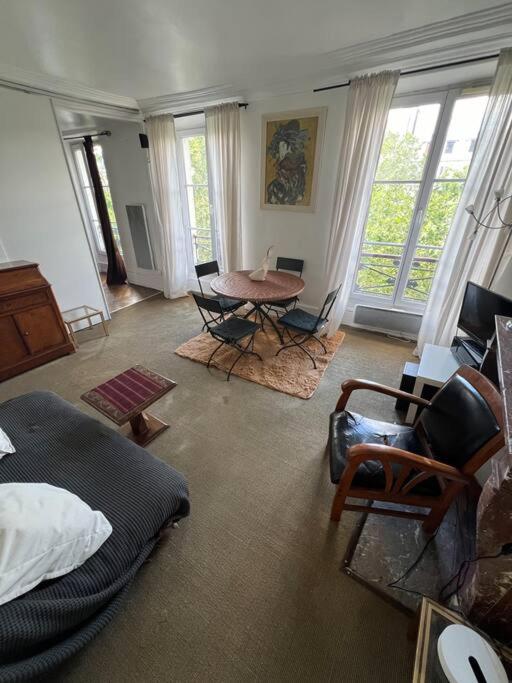 un salon avec une table et des chaises dans l'établissement Appartement central Paris, à Paris