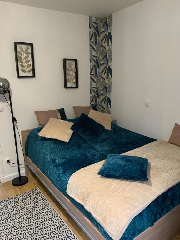 a bedroom with a large bed with blue sheets at Hébergement à Everly in Éverly