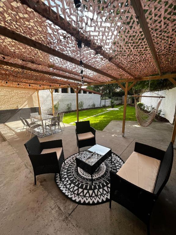a patio with chairs and tables under a roof at Jardín en el centro Catedral in Oviedo