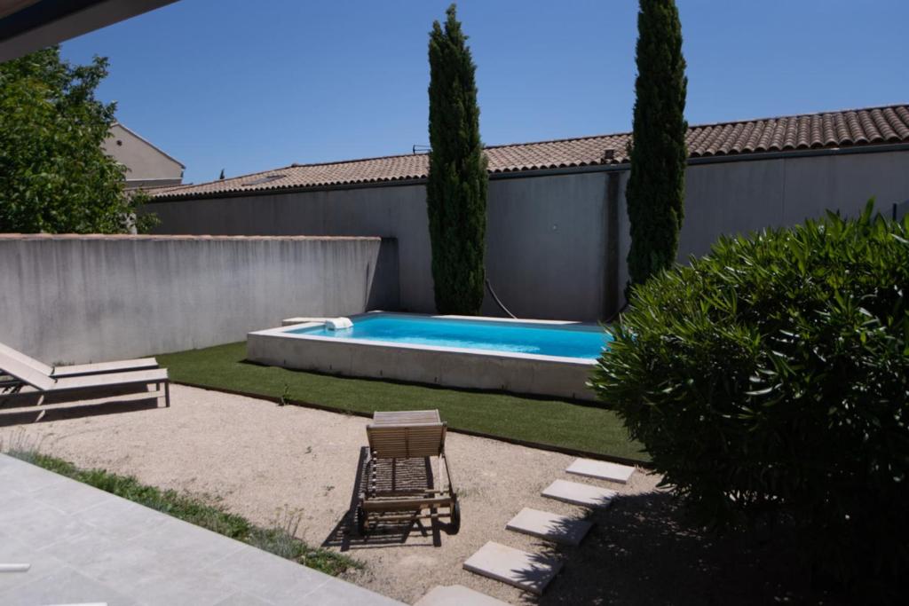 une arrière-cour avec une piscine et une chaise dans l'établissement Villa Anna - piscine privée proche du centre historique, à LʼIsle-sur-la-Sorgue