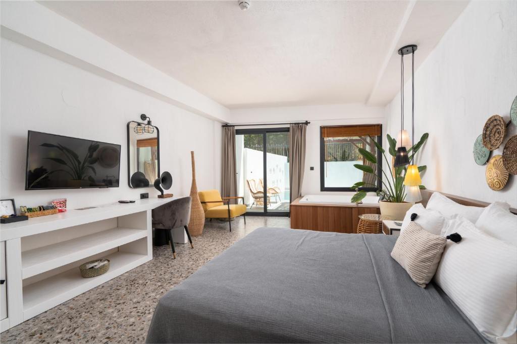 a bedroom with a bed and a desk with a television at Ölüdeniz Blu Luxury Unique Hotel - Adults-Only in Oludeniz