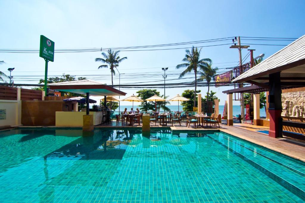 a swimming pool with tables and chairs in a resort at Sarita Chalet & Spa Hotel - SHA Extra Plus in Jomtien Beach