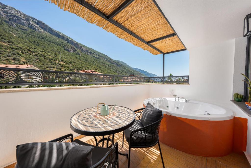 a balcony with a tub and a table and chairs at Ölüdeniz Blu Luxury Unique Hotel - Adults-Only in Oludeniz