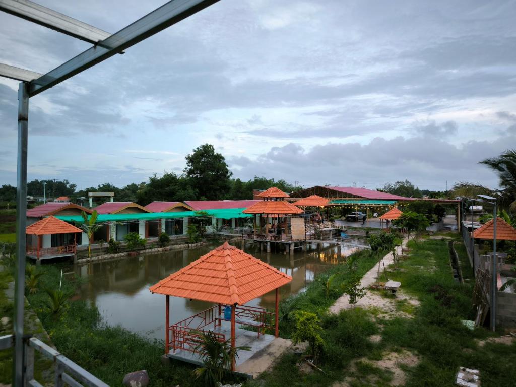 a group of buildings with orange umbrellas and water at Homestay 1999 in Tân Tạo