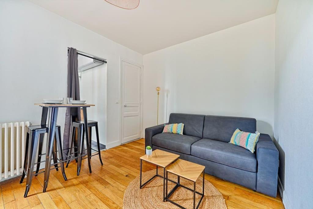 un salon avec un canapé bleu et une table dans l'établissement Melanie house, à Saint-Ouen