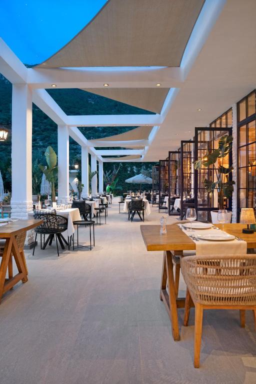 a restaurant with wooden tables and chairs and tablesearcher at Ölüdeniz Blu Luxury Unique Hotel - Adults-Only in Oludeniz
