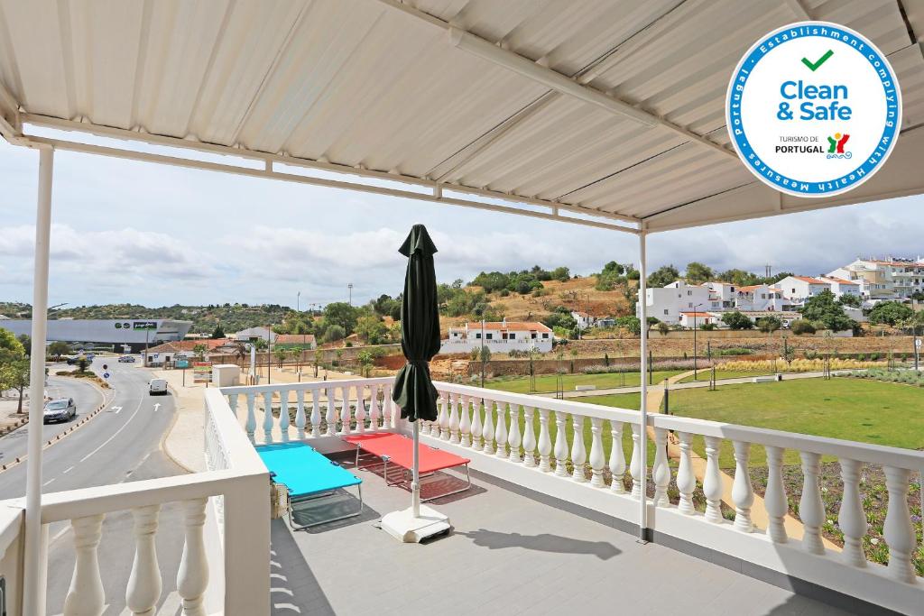 - Balcón con sombrilla y vistas a la carretera en Sweet Spot Marina Apartments, en Lagos