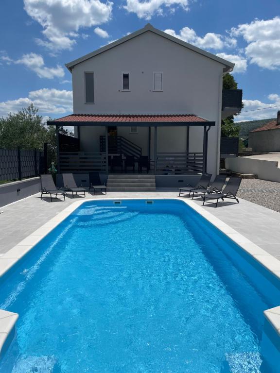 a villa with a swimming pool and a house at Villa Mirta in Zmijavci