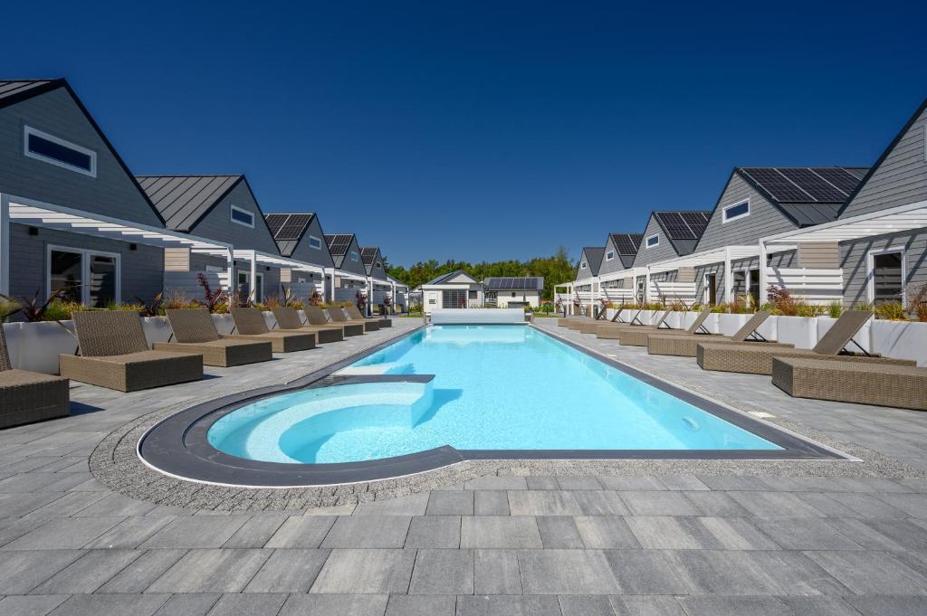 a swimming pool at a resort with lounge chairs at RESORT za lasem II in Jarosławiec