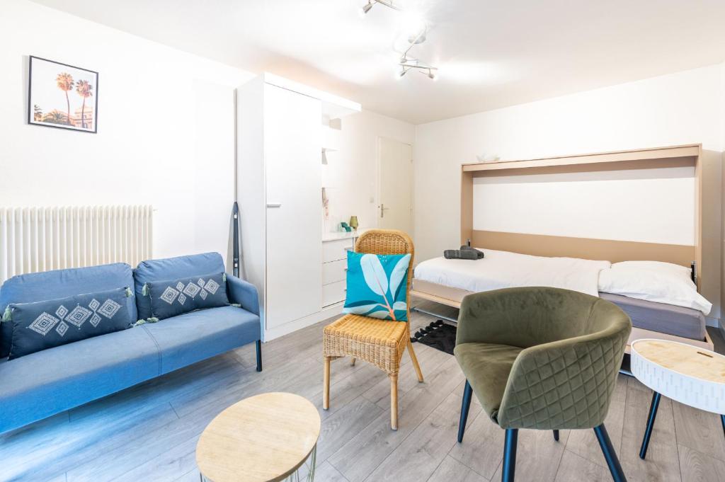 - un salon avec un canapé bleu et un lit dans l'établissement Marquer *M61* Jolie studio proche frontière, à Annemasse