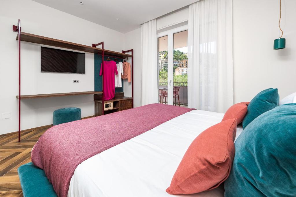 a bedroom with a large bed and a tv at Futura Funky House - De Vivo Realty Sorrento in Sorrento