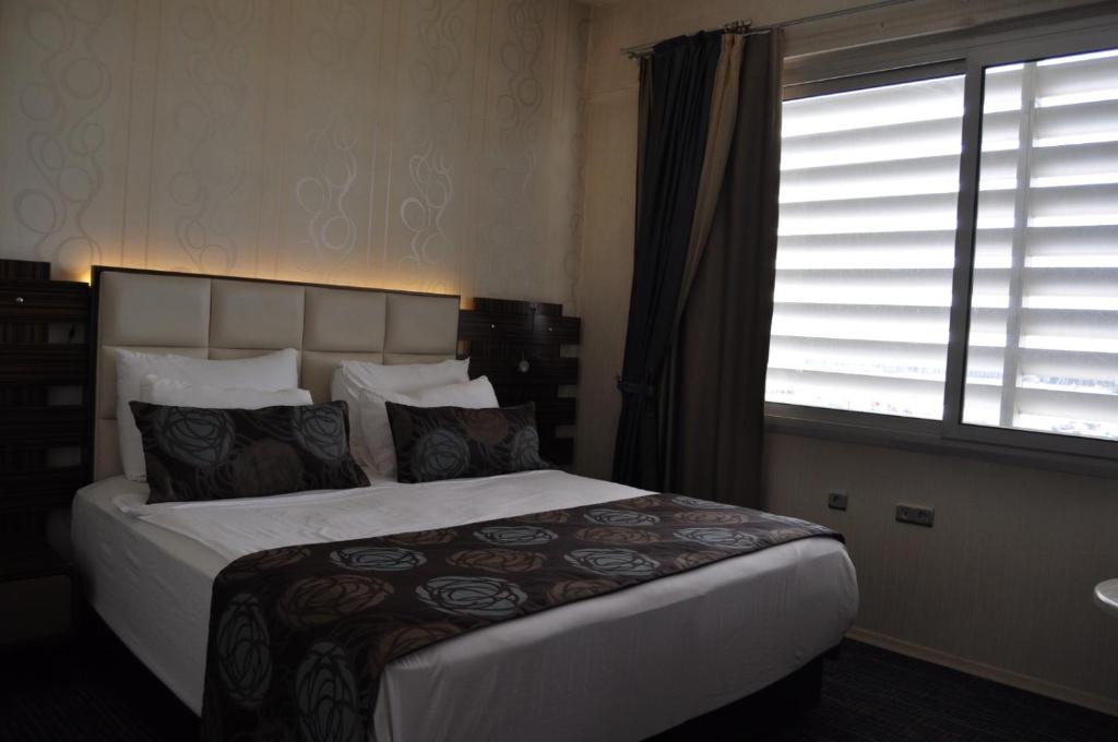 a bedroom with a large bed and a window at Orty Airport Hotel in Izmir