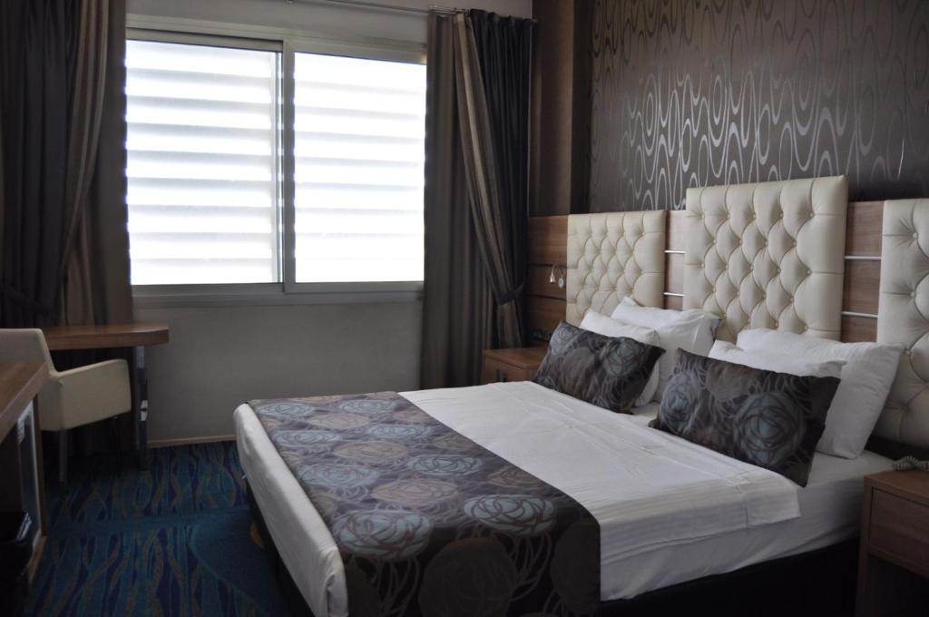 a hotel room with a bed with a window and a window at Orty Airport Hotel in Izmir
