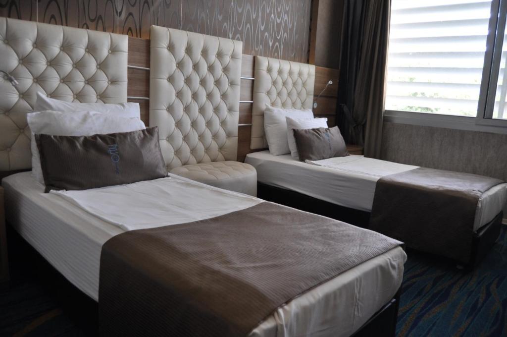 a hotel room with two beds and a window at Orty Airport Hotel in Izmir