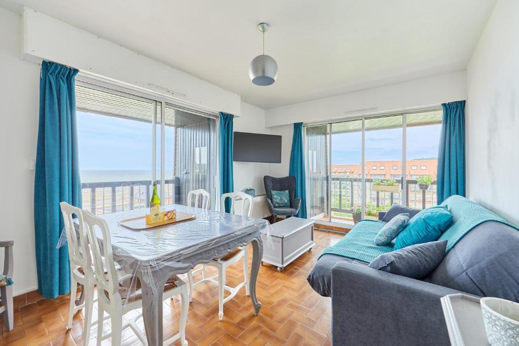 un salon avec une table et un canapé dans l'établissement Le Plein Soleil - Appt pour 6 proche de la plage, à Villers-sur-Mer