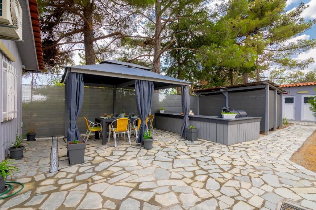 a patio with a table and an umbrella at Evaggelia's Summer Resort in Dhíkella
