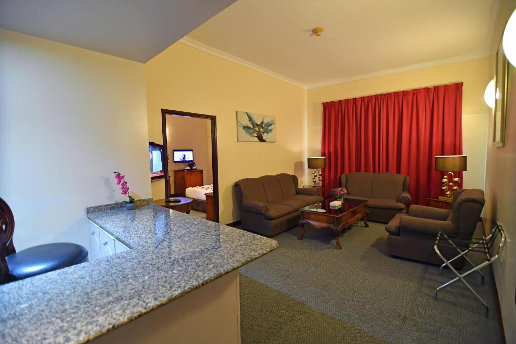a living room with a couch and a living room with a living room at Nejoum Al Emarat in Sharjah