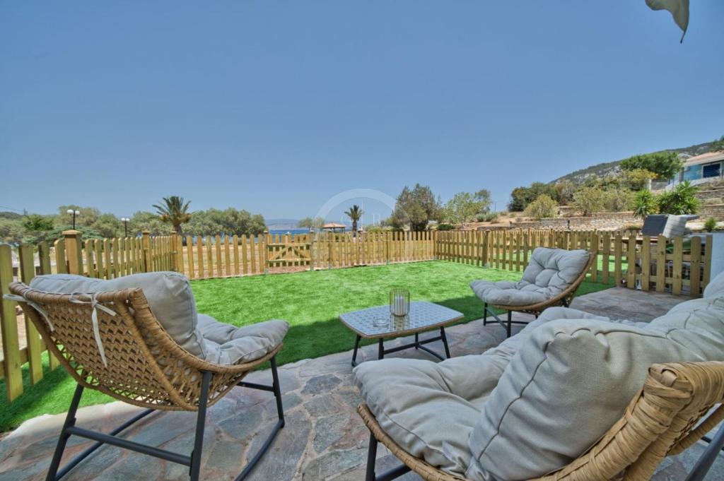 a patio with chairs and a table and a fence at Armonia Apartment in Ermioni