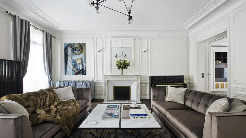 un salon avec deux canapés et une cheminée dans l'établissement Appartement - Trocadéro, à Paris