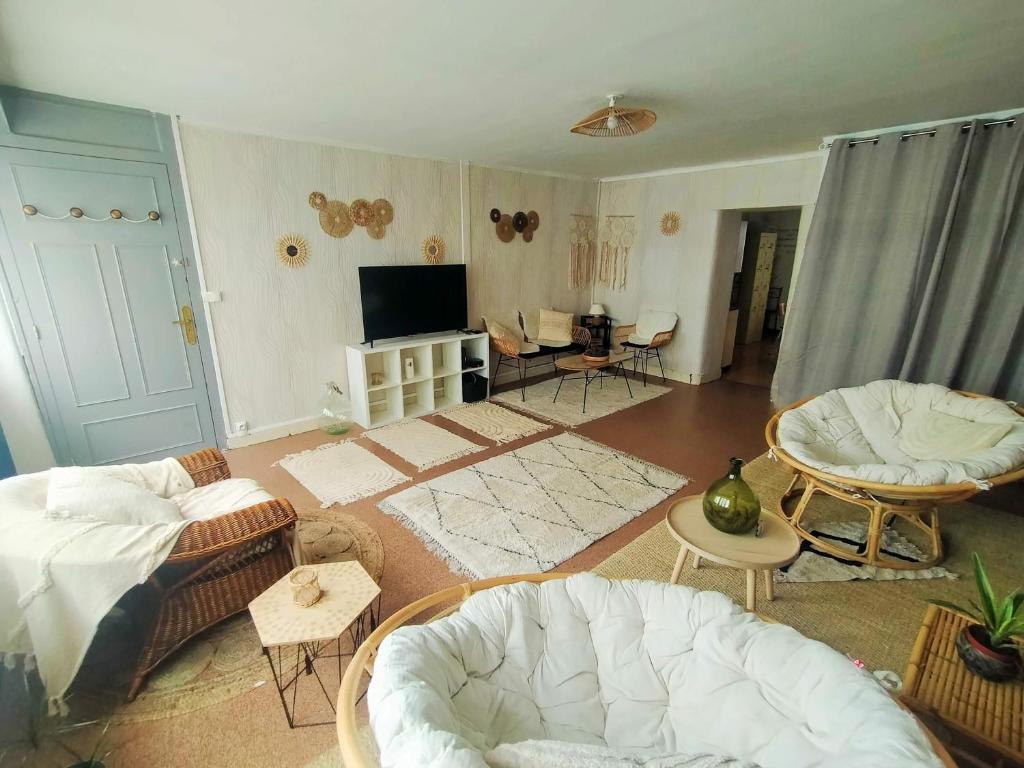 ein Wohnzimmer mit Sofa und Fernseher in der Unterkunft Au bonheur des voyageurs in Concarneau