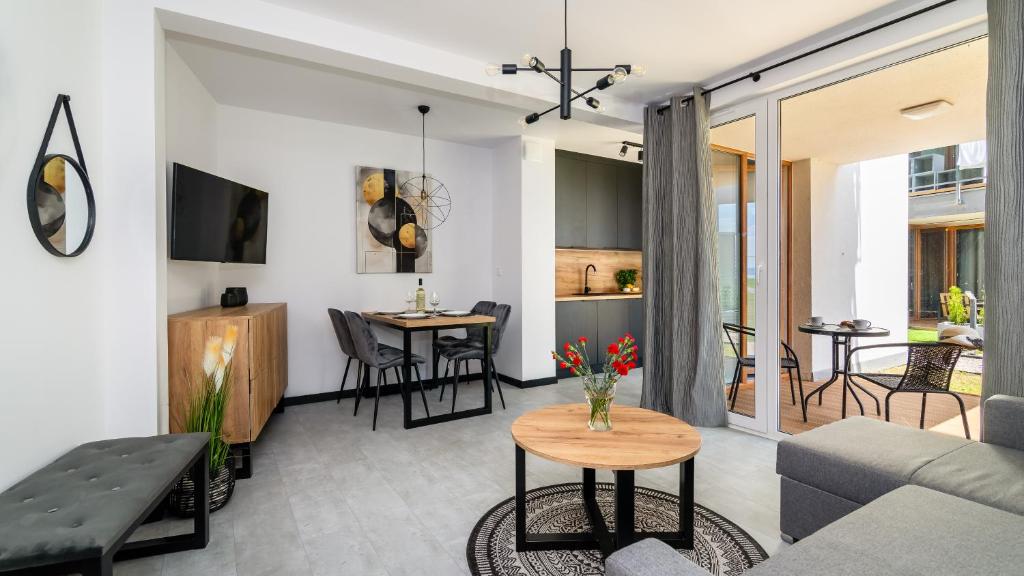 ein Wohnzimmer mit Sofa und Tisch in der Unterkunft ENKLAWA Apartamenty Piamola in Krynica Morska