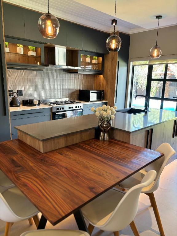 a kitchen with a wooden table and white chairs at 51 Carrington Way in Kimberley