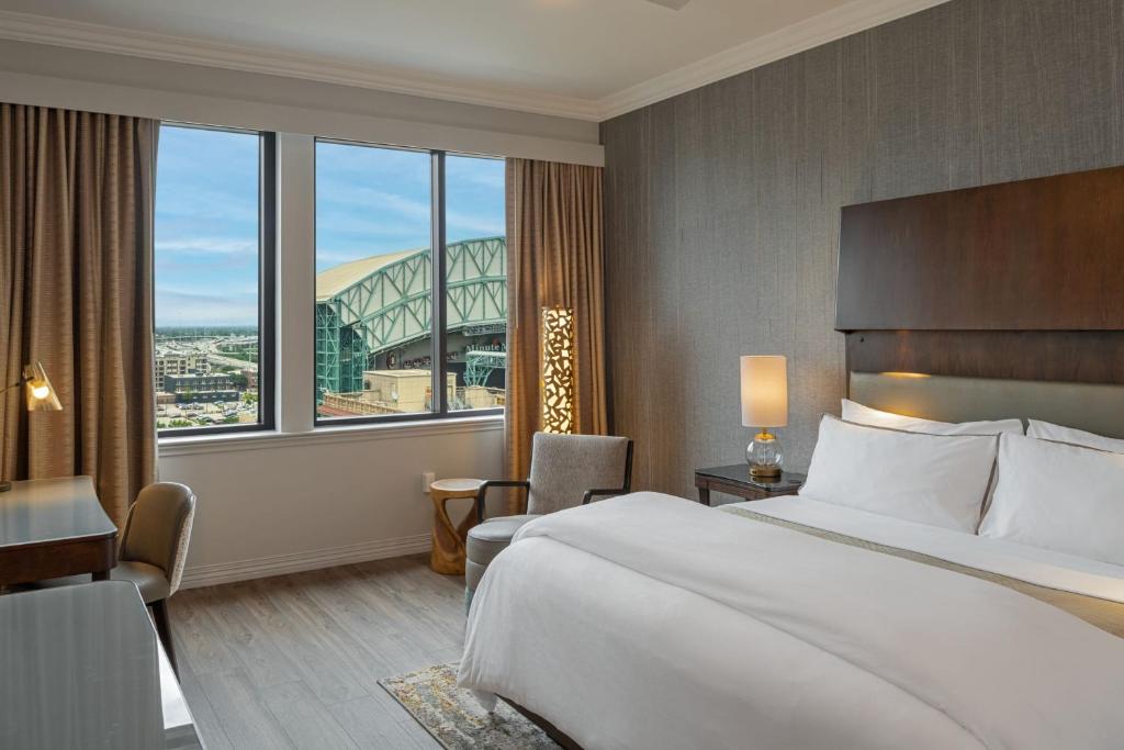 a hotel room with a bed and a large window at The Westin Houston Downtown in Houston