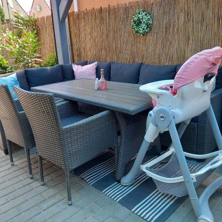 stół i krzesła na patio z różowym parasolem w obiekcie Gemini Vendégház w mieście Harkány