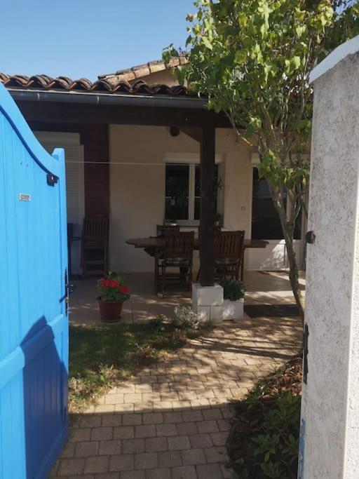 une maison avec une porte bleue et une terrasse dans l'établissement La Porte Bleue, à Vouneuil-sous-Biard
