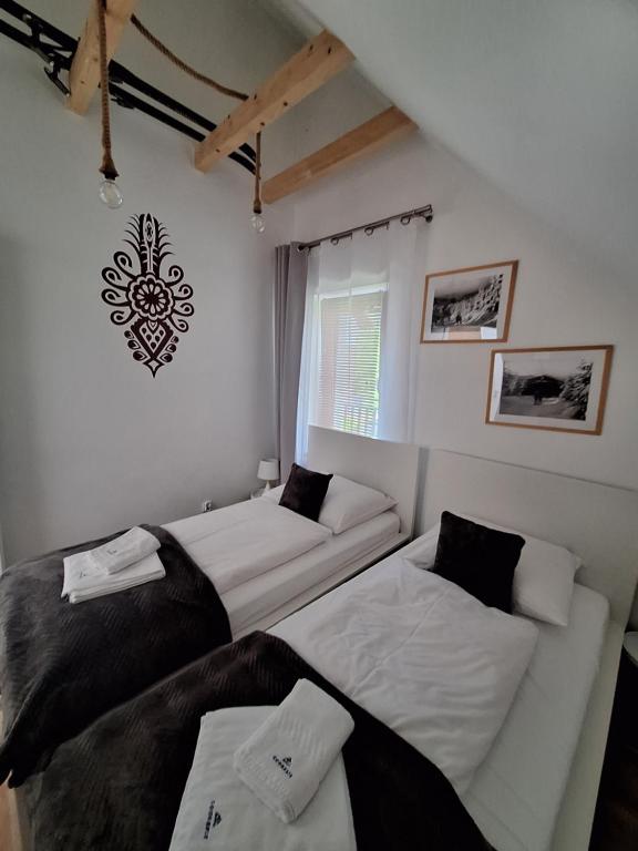 a room with two beds and a couch and a window at Goorskie - domki w Szczyrku in Szczyrk