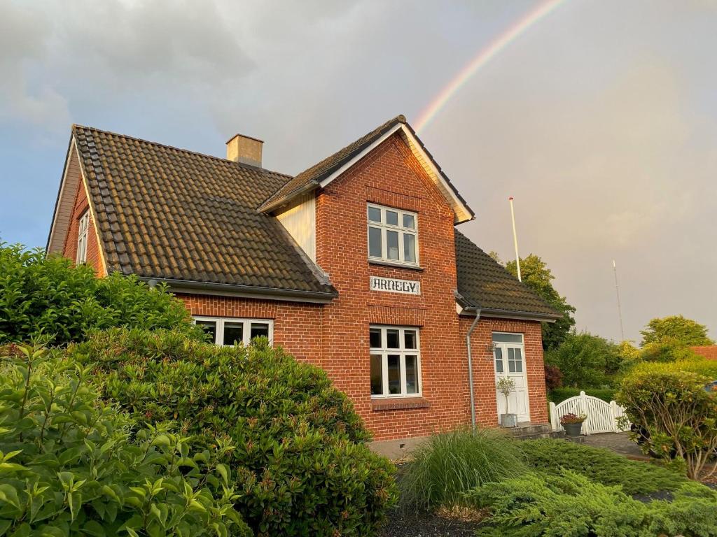 a rainbow over a brick house with at Wonderful house & garden in Tommerup