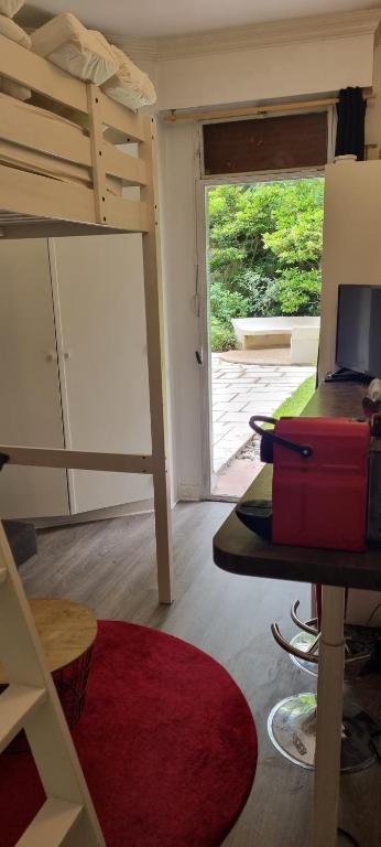 Cette chambre comprend des lits superposés et un bureau avec une valise. dans l'établissement Paris 16 studio 1, à Paris